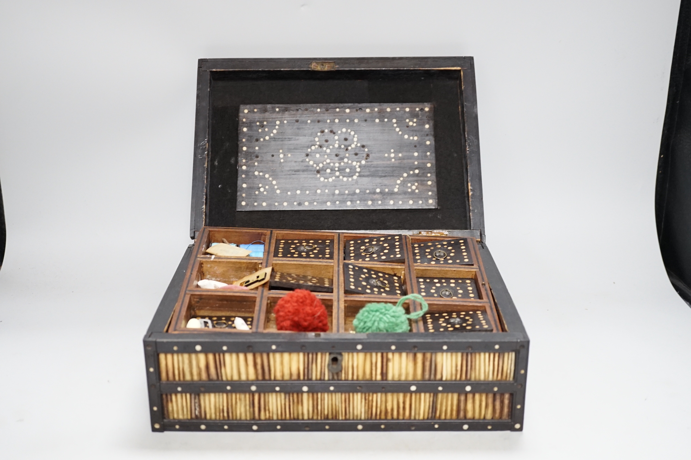 A 19th Century Ceylonese ebony, porcupine quill and bone inlaid sewing box with contents including cotton reels, 28cm wide